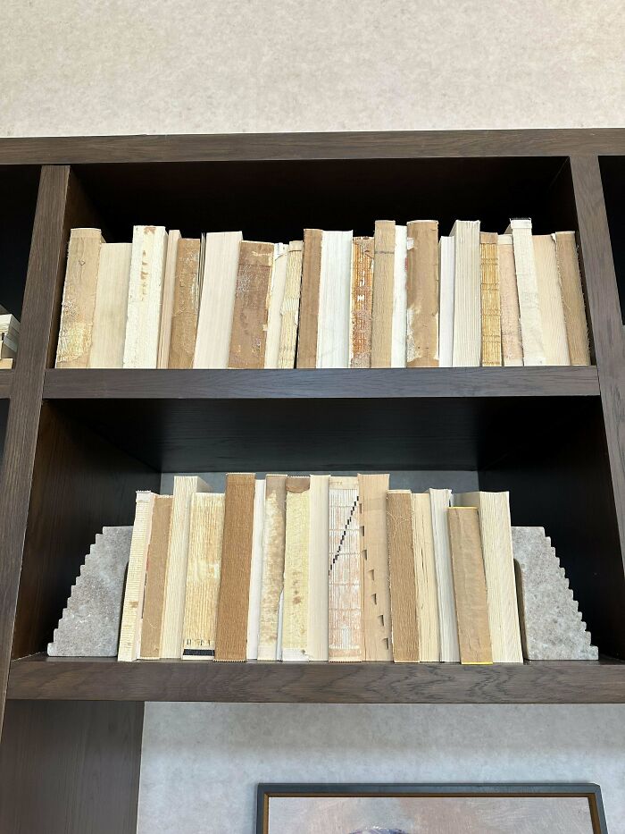 Libros colocados al revés en una estantería de madera, una imagen para arruinarte el día.