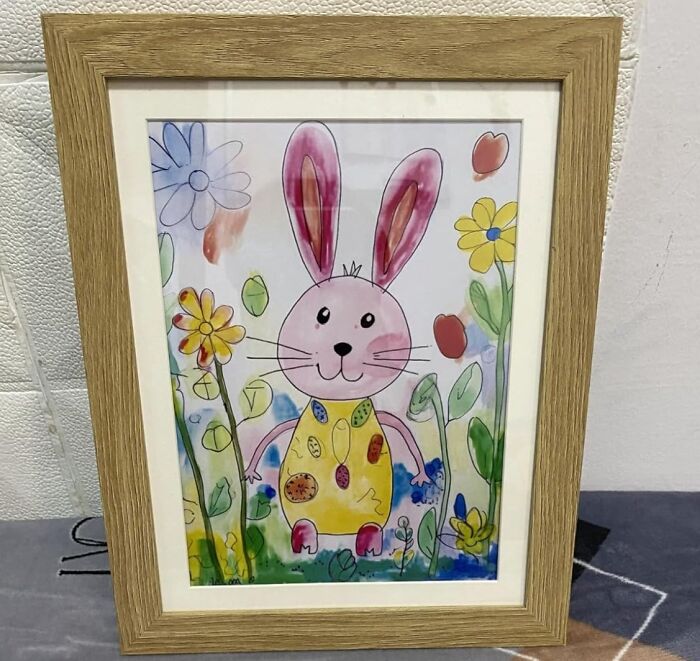 Framed children's drawing of a bunny in a garden, representing sentimental clutter.