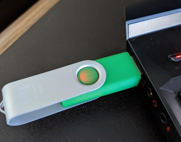 USB drive plugged into a laptop, ideal for storing sentimental clutter digitally.