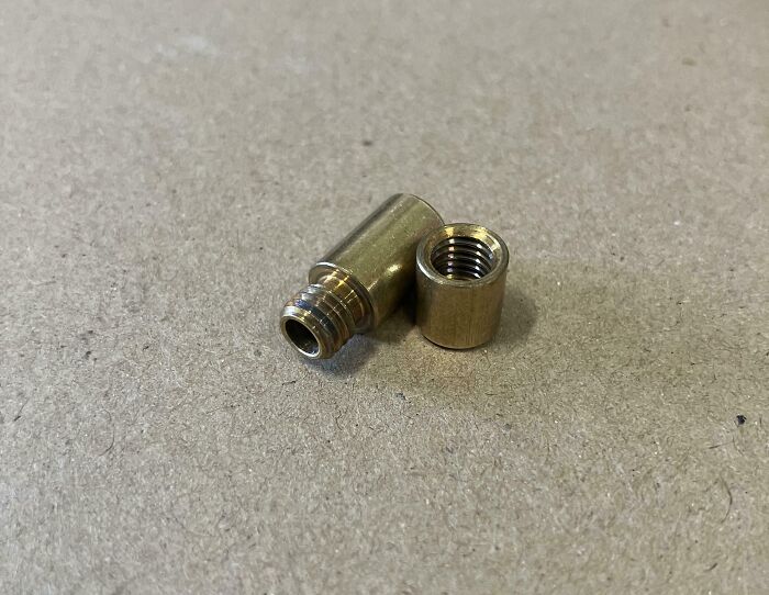 Brass connector piece found, puzzled people with weird objects discovered unexpectedly.