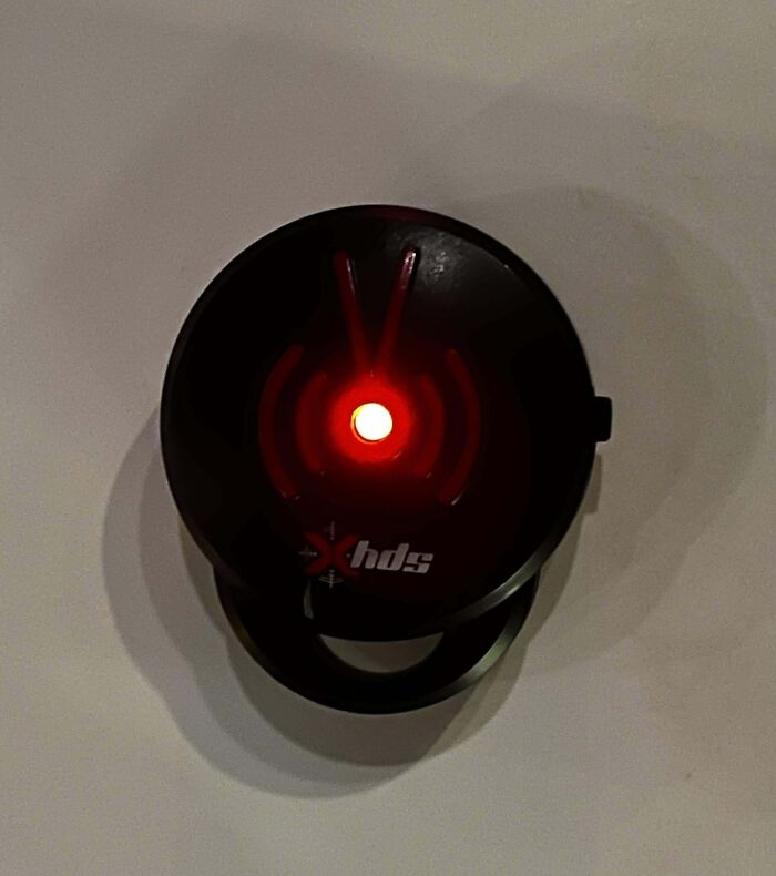 Mysterious circular object with a red LED light in the center, puzzling onlookers.