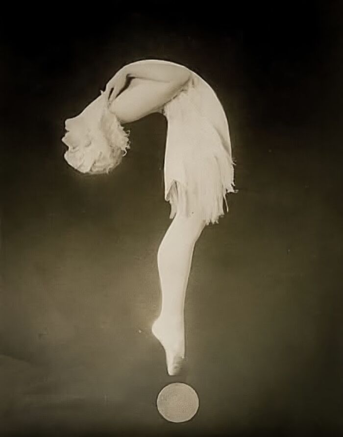 Acrobat in vintage attire balancing gracefully on a ball, showcasing timeless artistry from more than a hundred years ago.