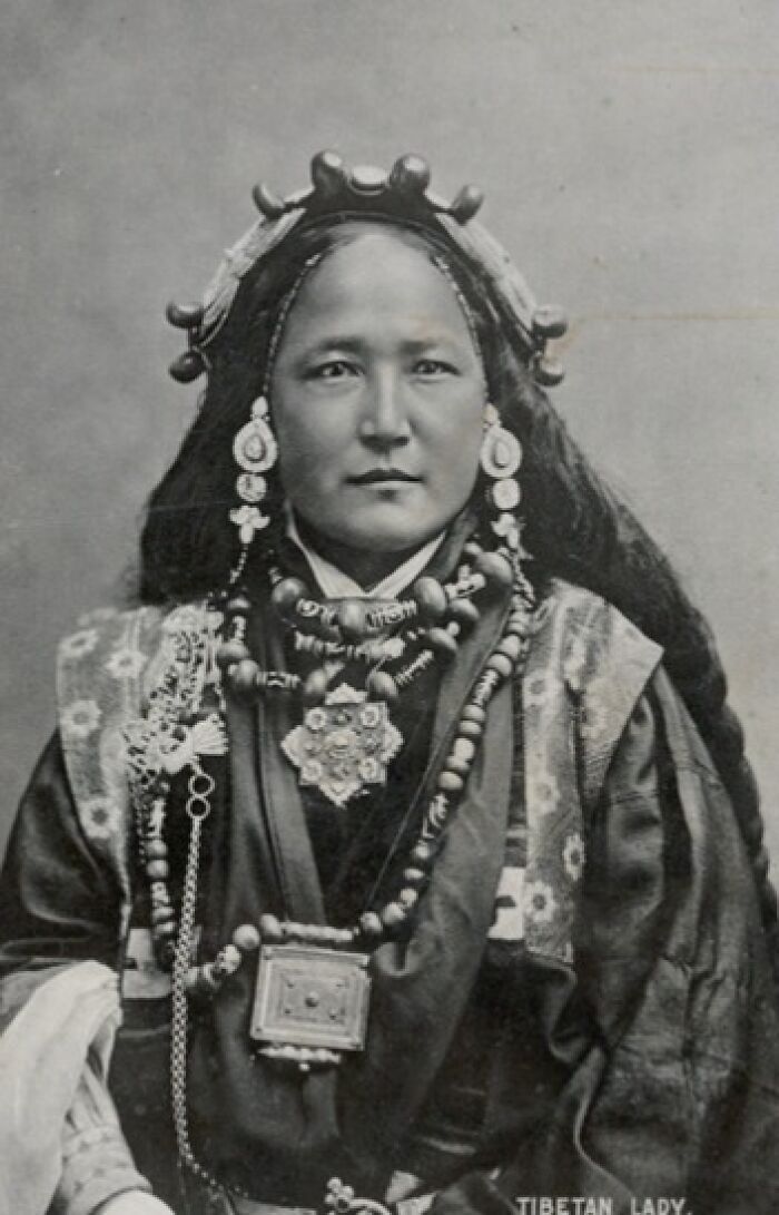 Historic photo of a Tibetan lady adorned in traditional attire, showcasing cultural resonance through time.