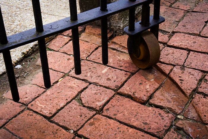 Old brick pavement with visible wear from gate wheel, demonstrating effects of things-used-over-time.