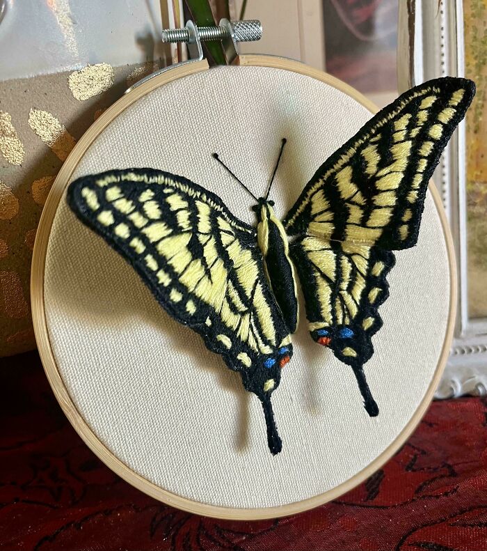 Embroidered yellow and black butterfly displayed in a wooden hoop showcasing beautiful embroidery skills and craftsmanship.