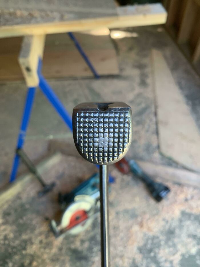 Close-up of a textured hammer head in a workshop setting, illustrating things used over time.