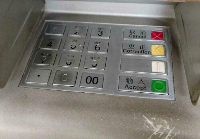 ATM keypad with buttons for cancel, correction, and accept.