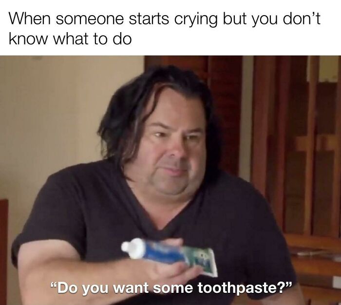 Man holding toothpaste in an awkward life moment, unsure how to react to someone crying.