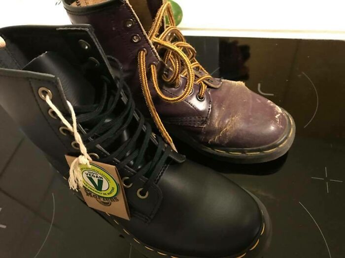 Worn and new boots side by side, illustrating things used over time, on a dark surface.