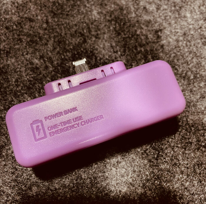 Purple one-time use power bank, a potential scam product, on a dark textured surface.
