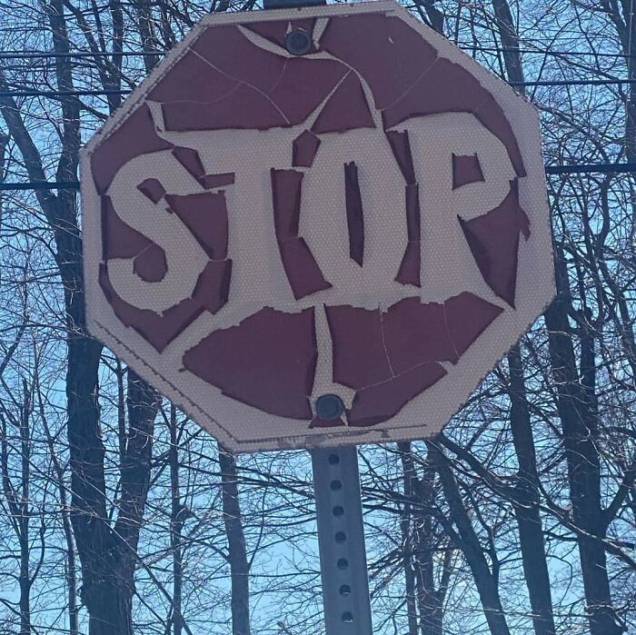 Damaged stop sign with visible cracks, illustrating the effects of time.