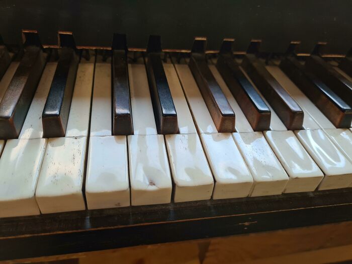 Aging piano keys showing wear, representing the impact of time on things.