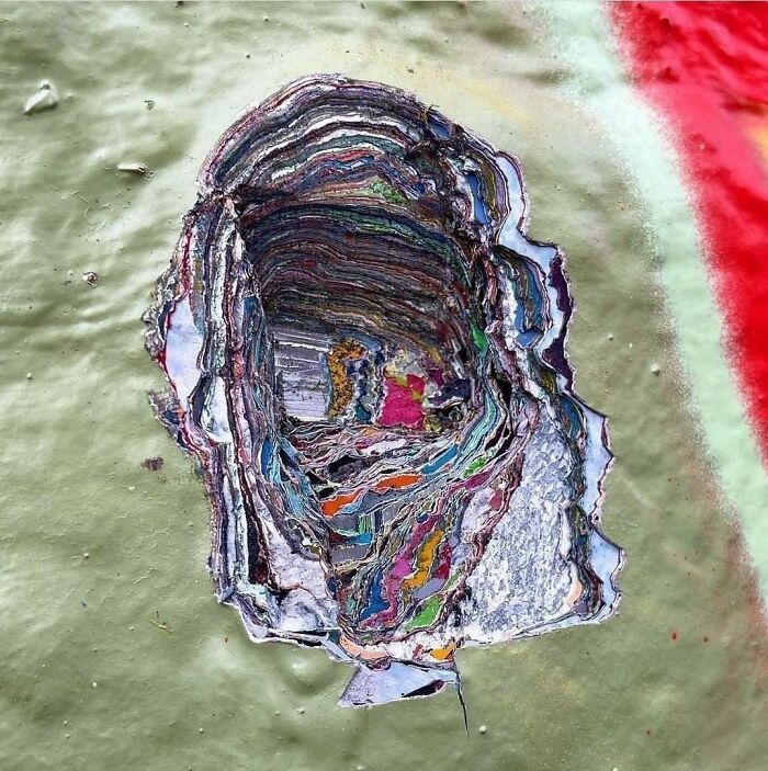 Close-up of layered paint chips resembling geological strata, illustrating Time-vs.-Things concept with vivid colors.