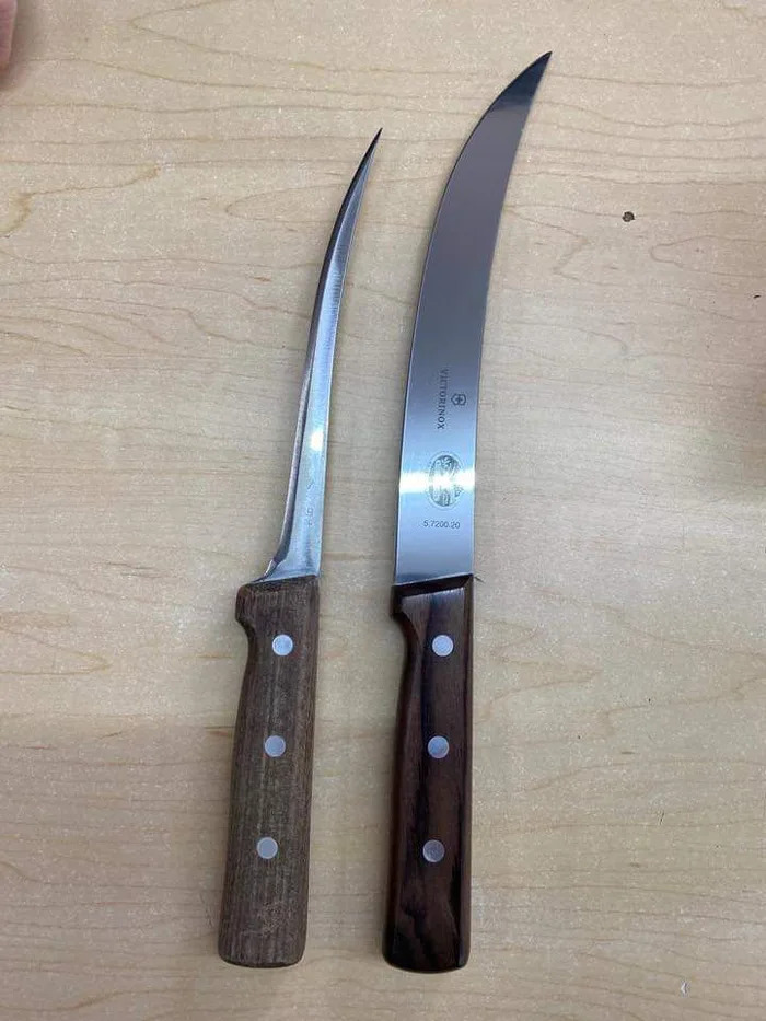 Two curved knives with wooden handles on a wooden surface, illustrating things.