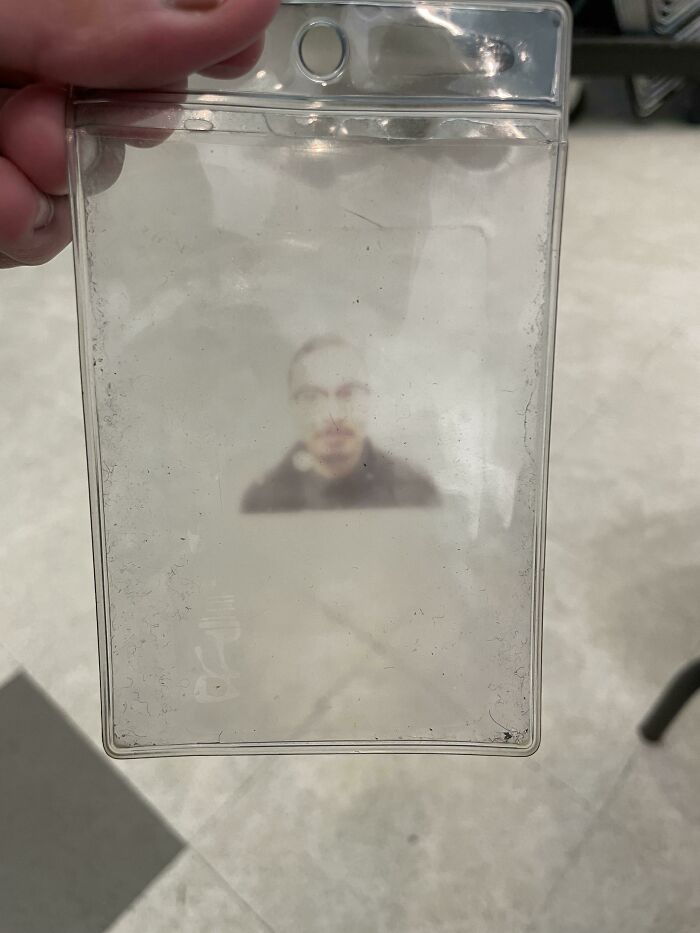 Blurred image of a person on an old ID badge, illustrating the theme of time versus things.