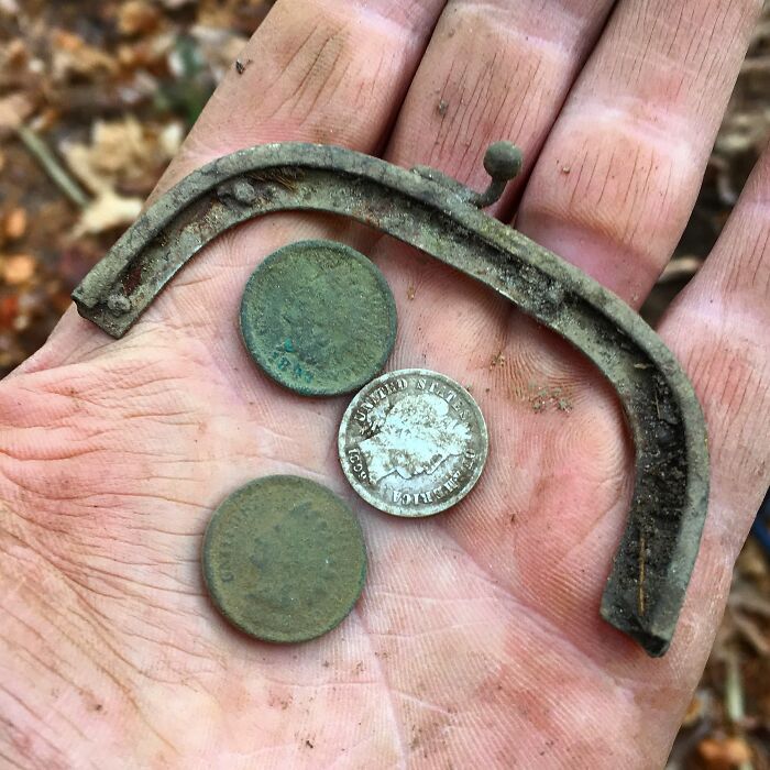 A hand holding antique coins and a vintage object, illustrating the passage of time against things.