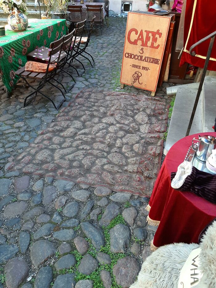 Outdoor café with cobblestone path, colorful tables, and vintage sign, illustrating the charm of time versus things.