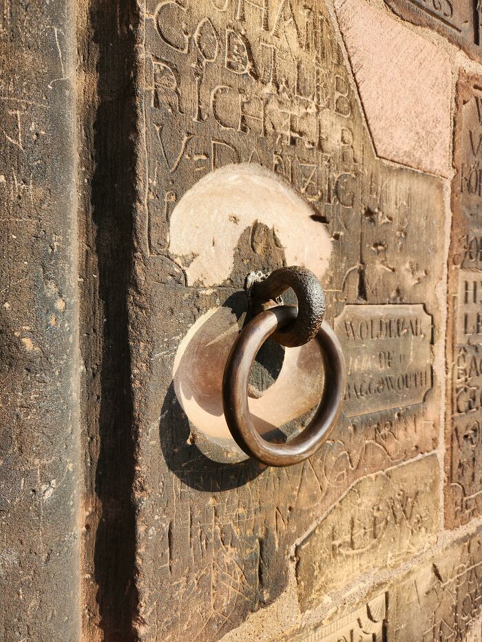 Ancient wall carvings with iron ring, showcasing the passage of time vs. things in historical architecture.