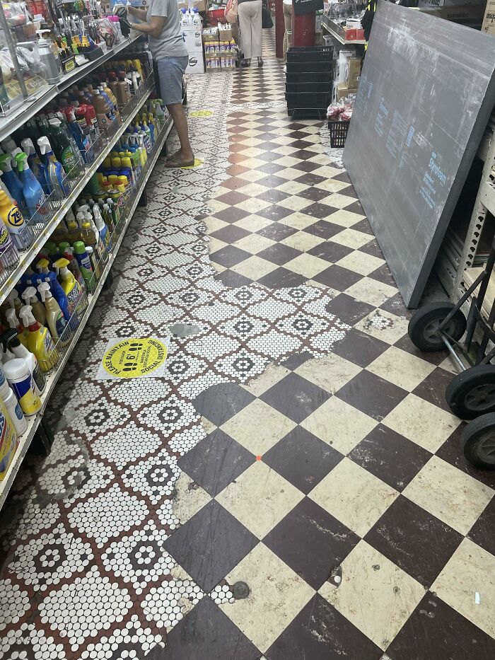 Checkered floor with intricate mosaic pattern in a store aisle, highlighting the contrast between time and things.