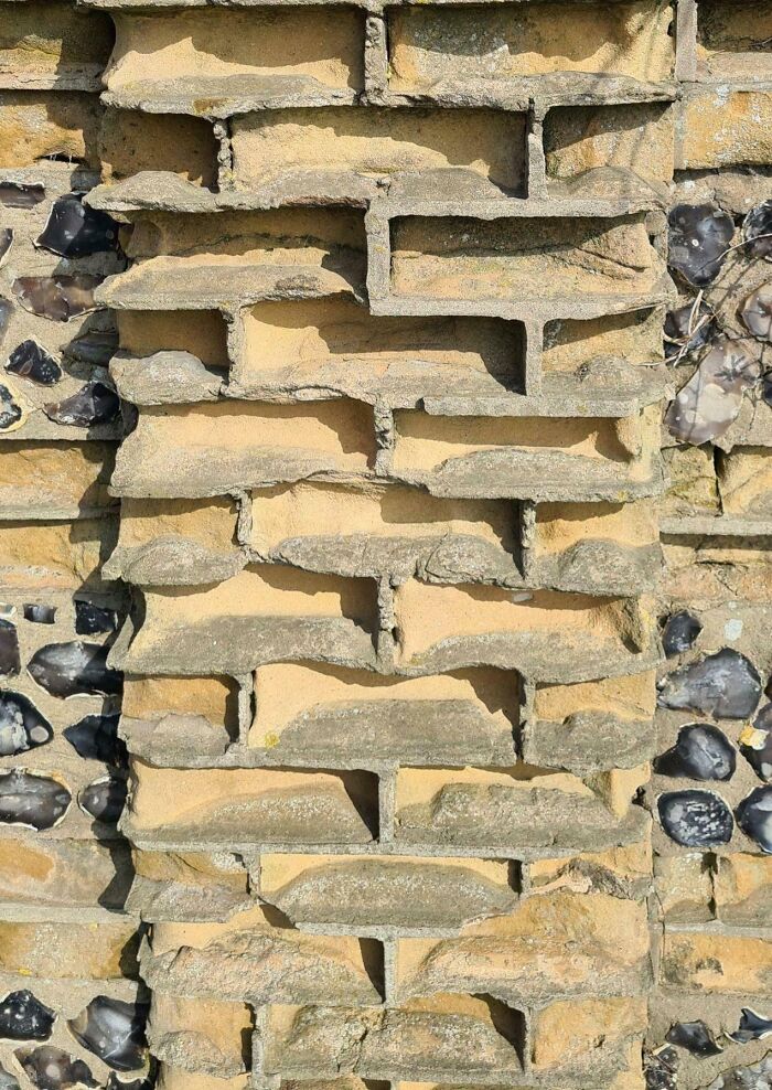 Rough stone wall with flint details, showcasing weathered textures.