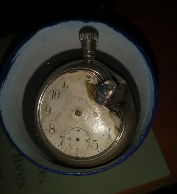 Old, broken pocket watch inside a blue container symbolizing Time vs. Things concept.