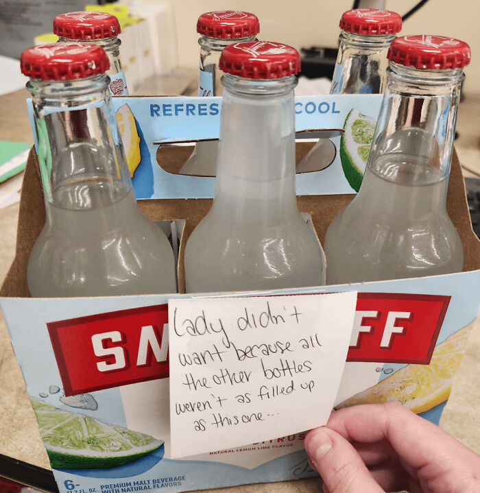 A note on a Smirnoff six-pack highlights customer cluelessness about bottle fill levels.