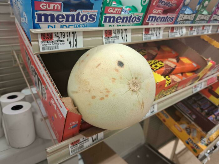 Melon misplaced on a candy shelf in a store, illustrating customer cluelessness.