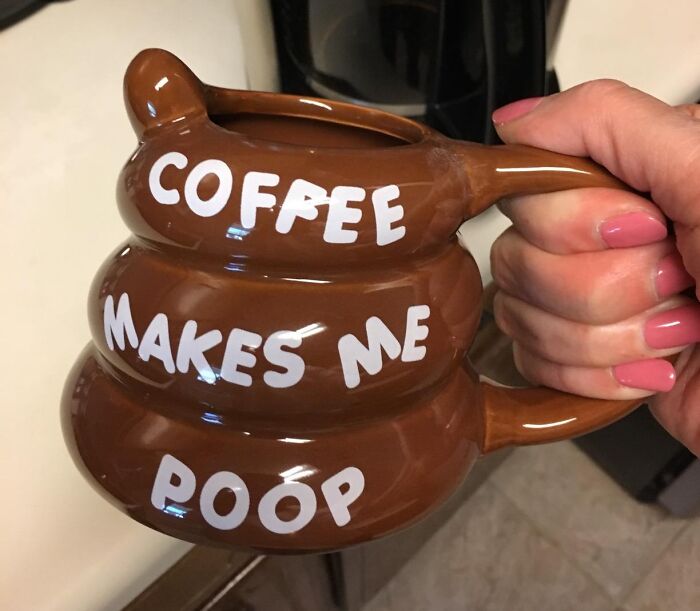 A novelty mug shaped like p**p with the text "Coffee makes me p**p," showcasing toilet humour.