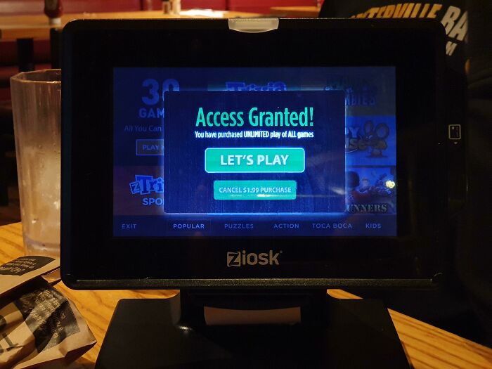 Tablet displaying an "Access Granted" message for unlimited games, highlighting shameless scams targeting intelligence.