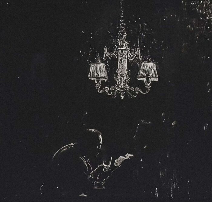 Dark eerie painting with figures under a chandelier, inspired by industrial decay and folklore.