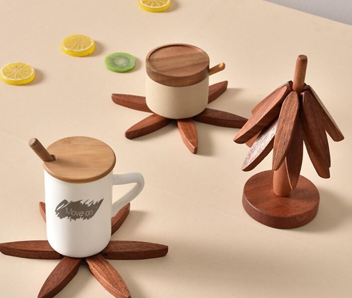 Wooden sneakily useful decor items including cup coasters and a decorative tree on a beige surface with fruit slices nearby.