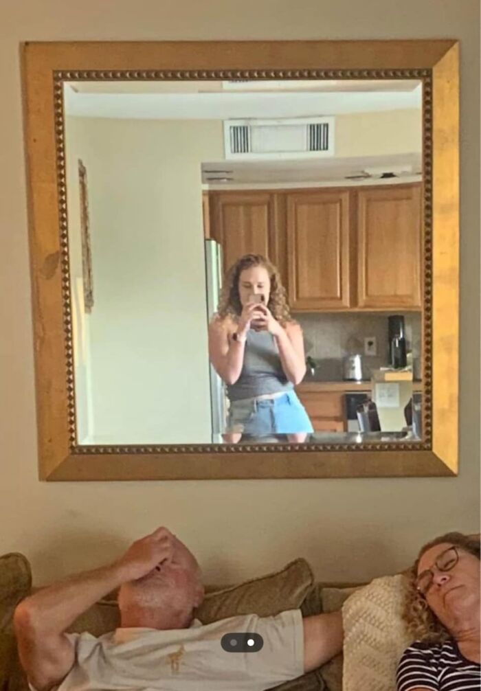 Woman taking a mirror selfie above two people on a couch; an example of a bad Facebook Marketplace post.