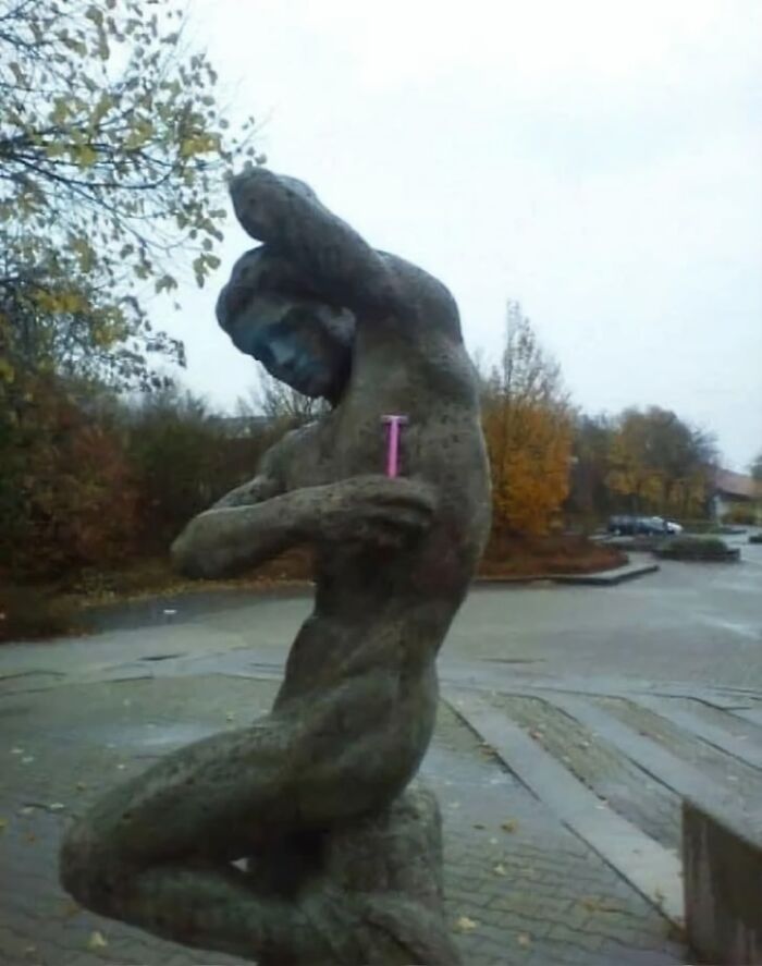 Funny statue with a pink razor under its arm, creating humor without needing any context.