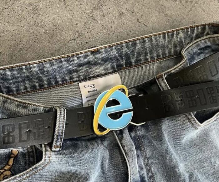 Jeans with a belt featuring a humorous Internet Explorer buckle.