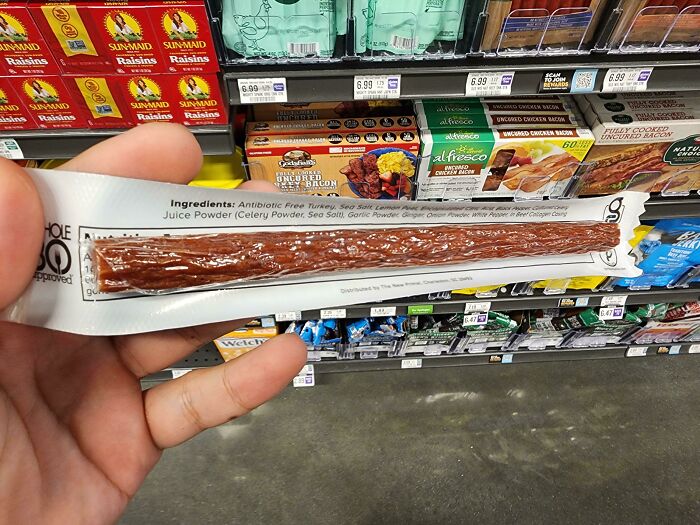 Design fail: Jerky packaging misprint with wrong ingredients, held in hand in a grocery aisle.