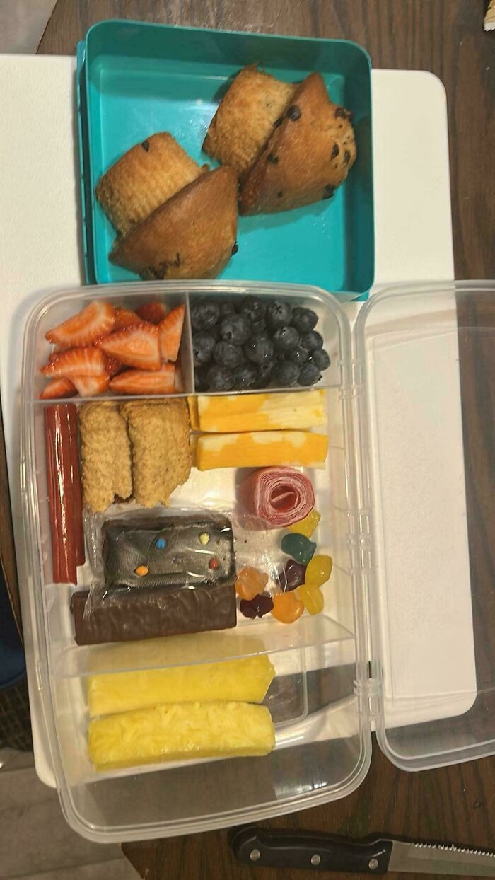 Packed lunchbox with fruit, snacks, and treats, showcasing wholesome parenting moments dads create with care.