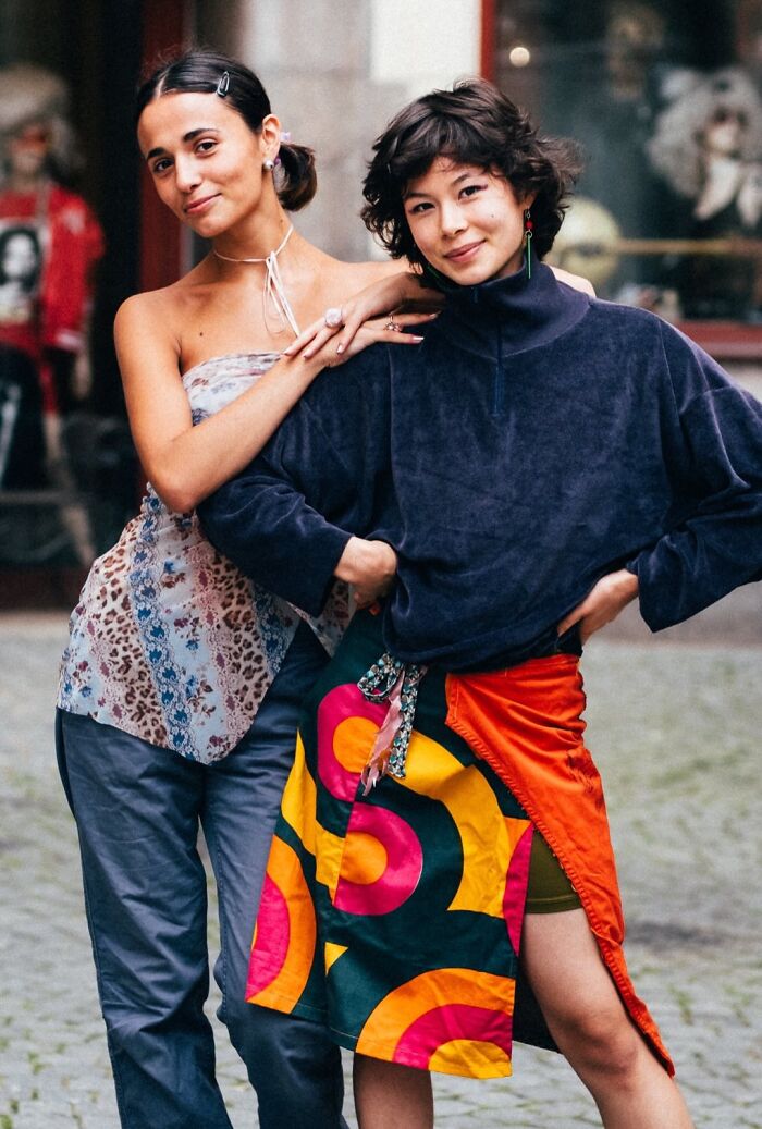 Two visually striking strangers pose in colorful street fashion for a portrait.