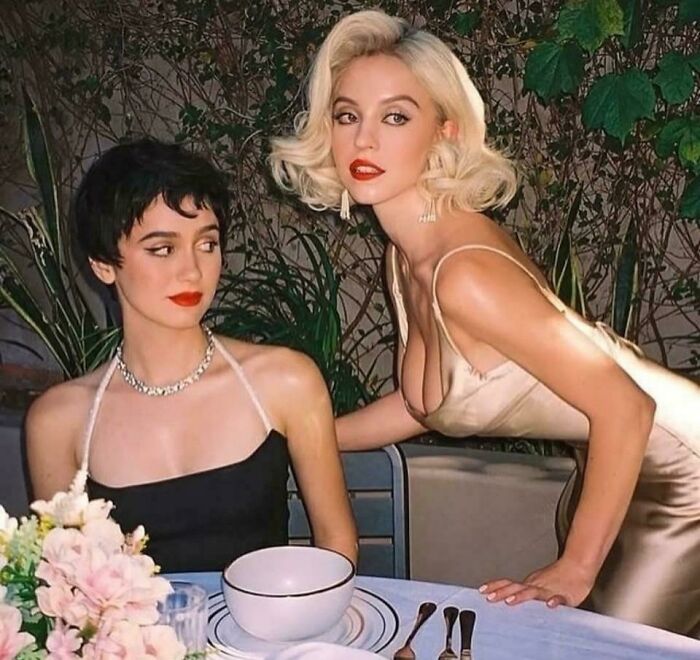 Two women dressed elegantly at a table, illustrating Instagram vs reality contrast in posed lifestyle pics.