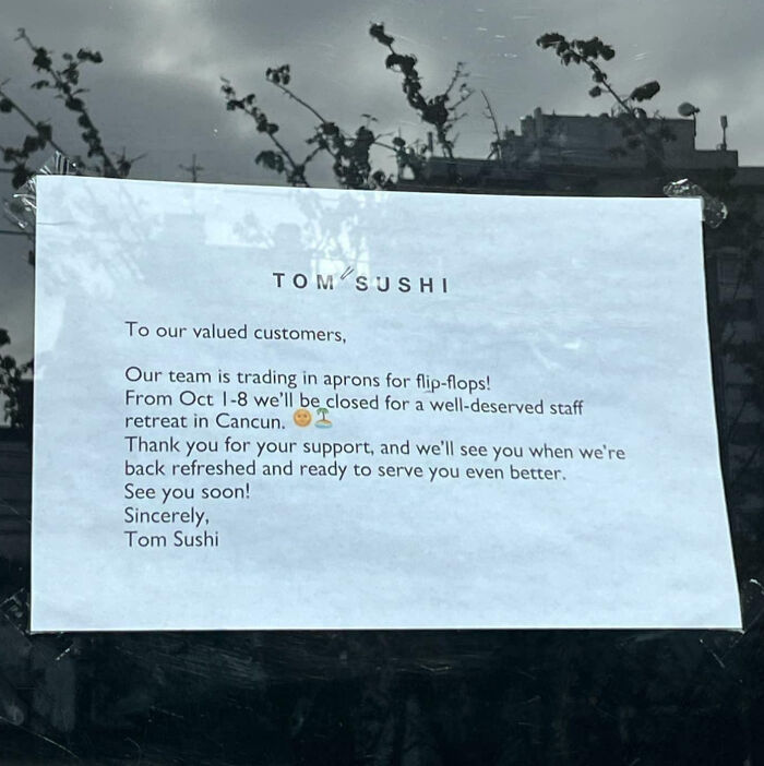 Notice on a restaurant window humorously announcing temporary closure for staff retreat in a Canada setting.