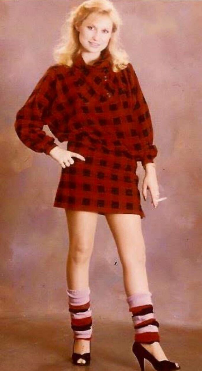 Young woman in vintage red checkered dress and leg warmers, a candid glimpse into the past fashion style.