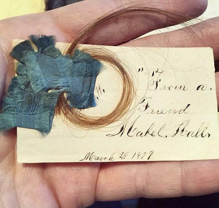 Unique bookmark with lock of hair and handwritten note from 1878, shared by a book lover.