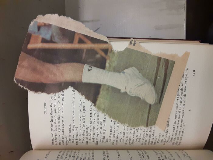 Unique bookmark made from a torn magazine page placed inside an open book.