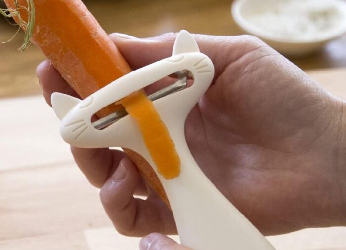 Peleg Design Shop cat-shaped peeler in use on a carrot.