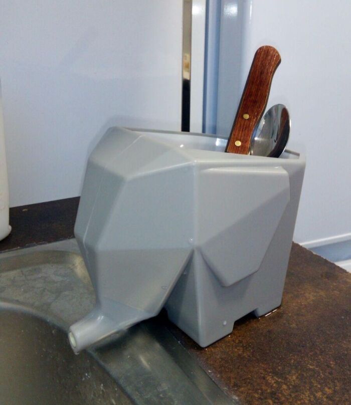 Gray elephant-shaped utensil holder by Peleg Design beside a kitchen sink.