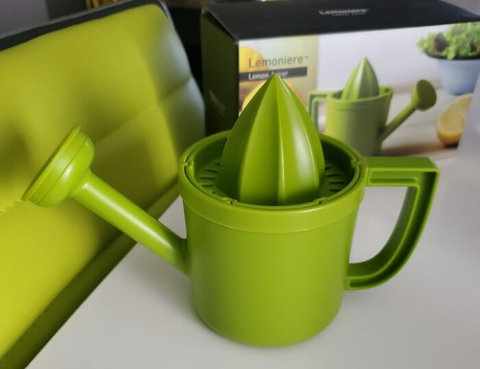 Green lemon juicer shaped like a watering can from Peleg Design Shop in a modern kitchen setting.
