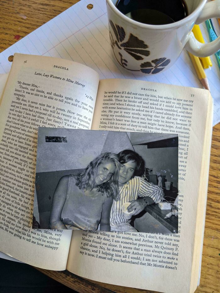 Vintage photo bookmark in an open book with coffee nearby, creating a cozy scene for book lovers.