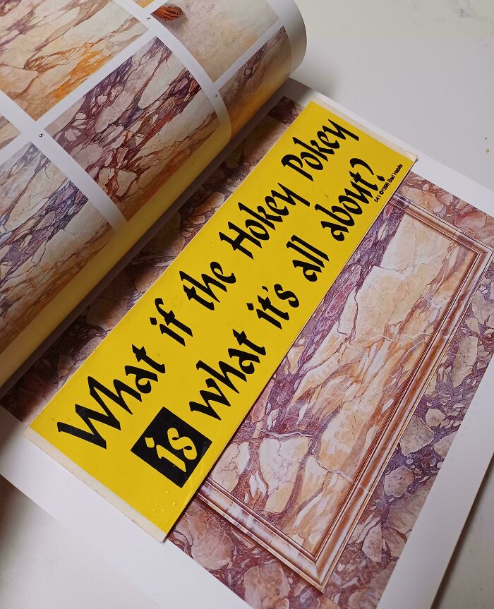 Yellow bookmark in a book with "What if the Hokey Pokey is what it's all about?" printed on it.