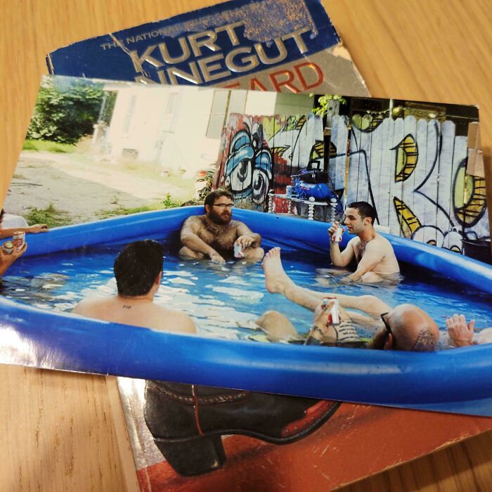 Unique bookmark on top of a Kurt Vonnegut book featuring friends relaxing in an inflatable pool.