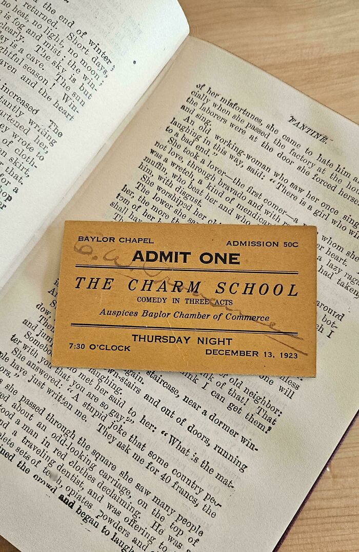 Vintage theater ticket used as a bookmark in an open book.