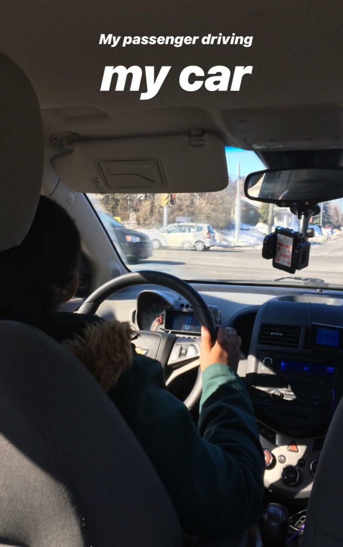 Passenger driving a car in Canada during winter, showcasing a common Canadian driving experience on snowy roads.